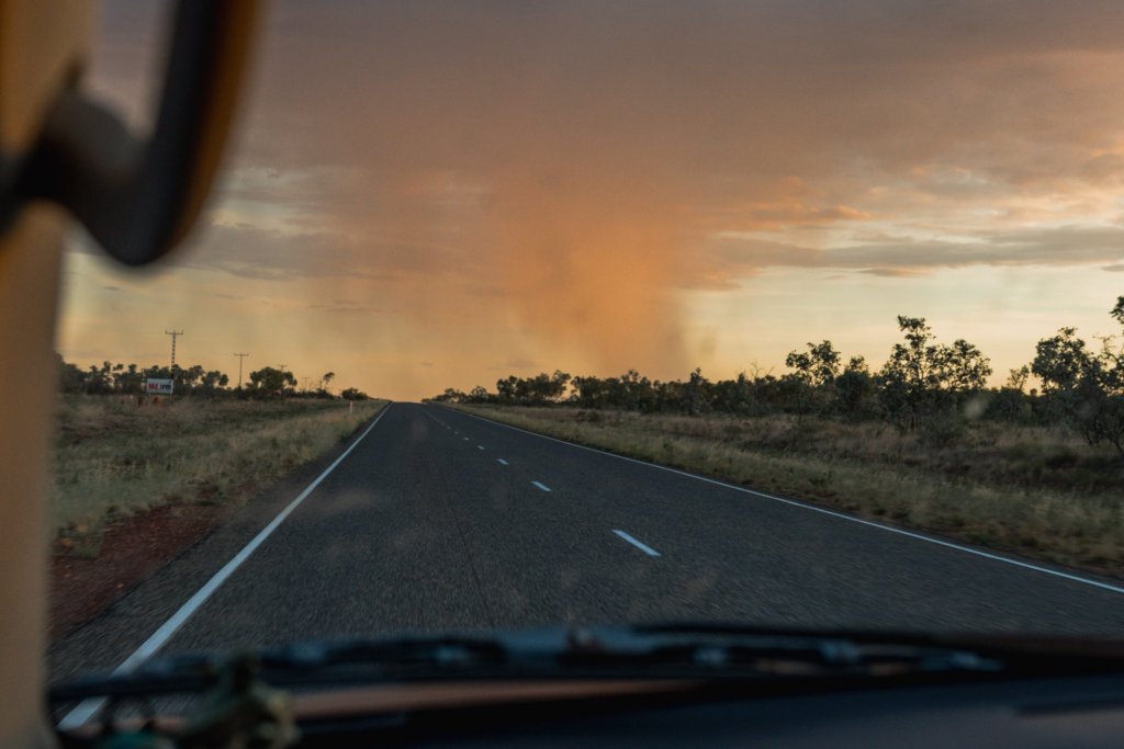Road on a highway with a dramatic sky over a flat landscape.