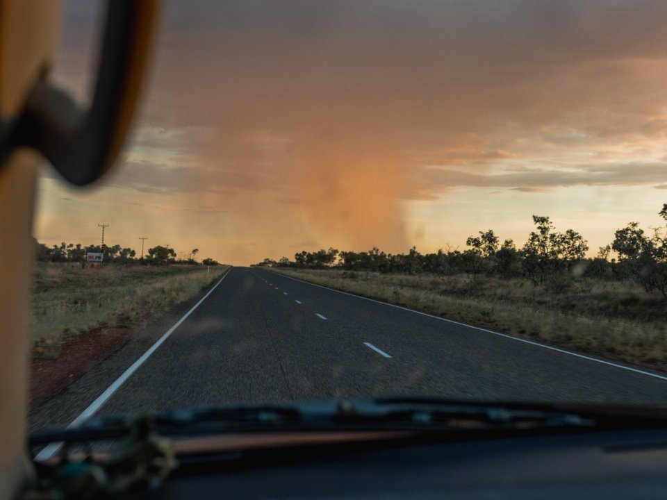 Road on a highway with a dramatic sky over a flat landscape.