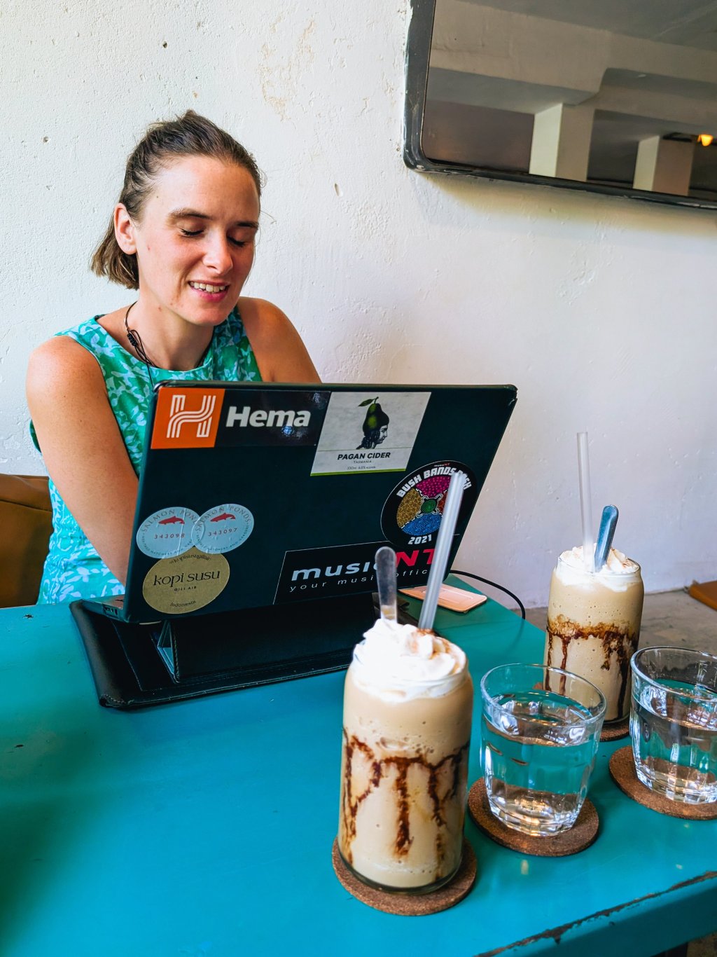 Woman smiling while holding a beverage at a cafe in Ho Chi Minh City.