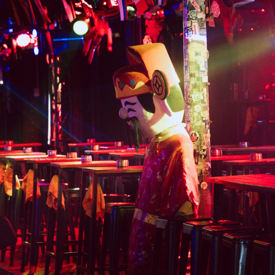 Interior view of a dimly lit bar or venue with people and decorations.