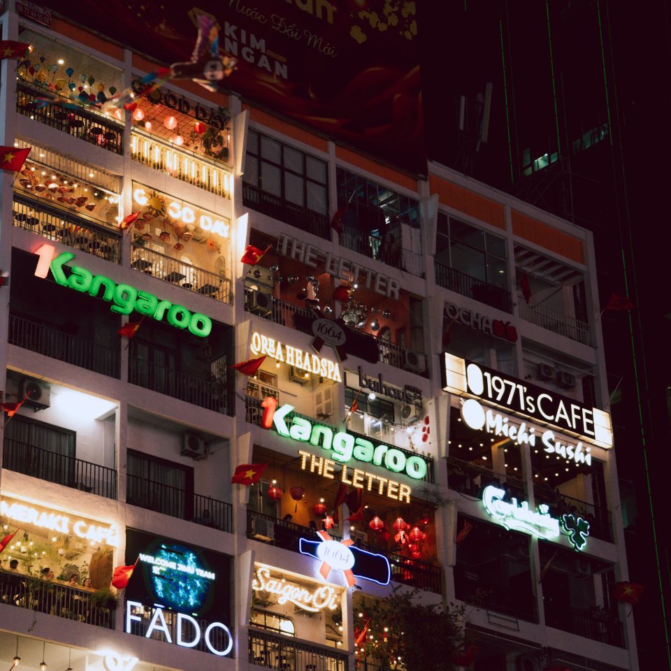 Night view of a busy street with illuminated storefronts in Ho Chi Minh City.