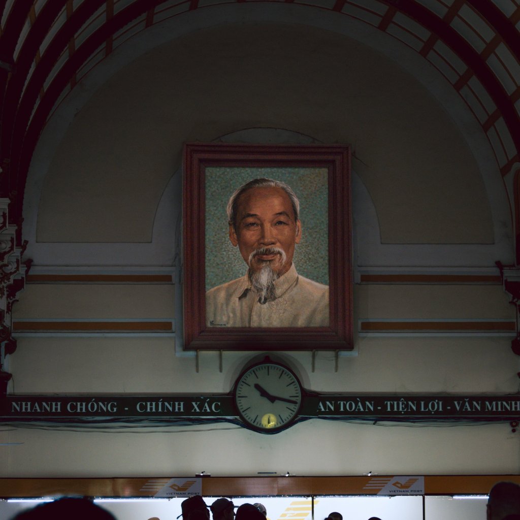Interior view of a space with framed portraits and a clock in a hall.