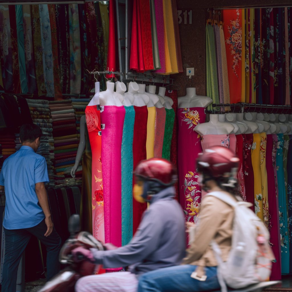 Close-up view of colourful textiles hanging in a market setting.