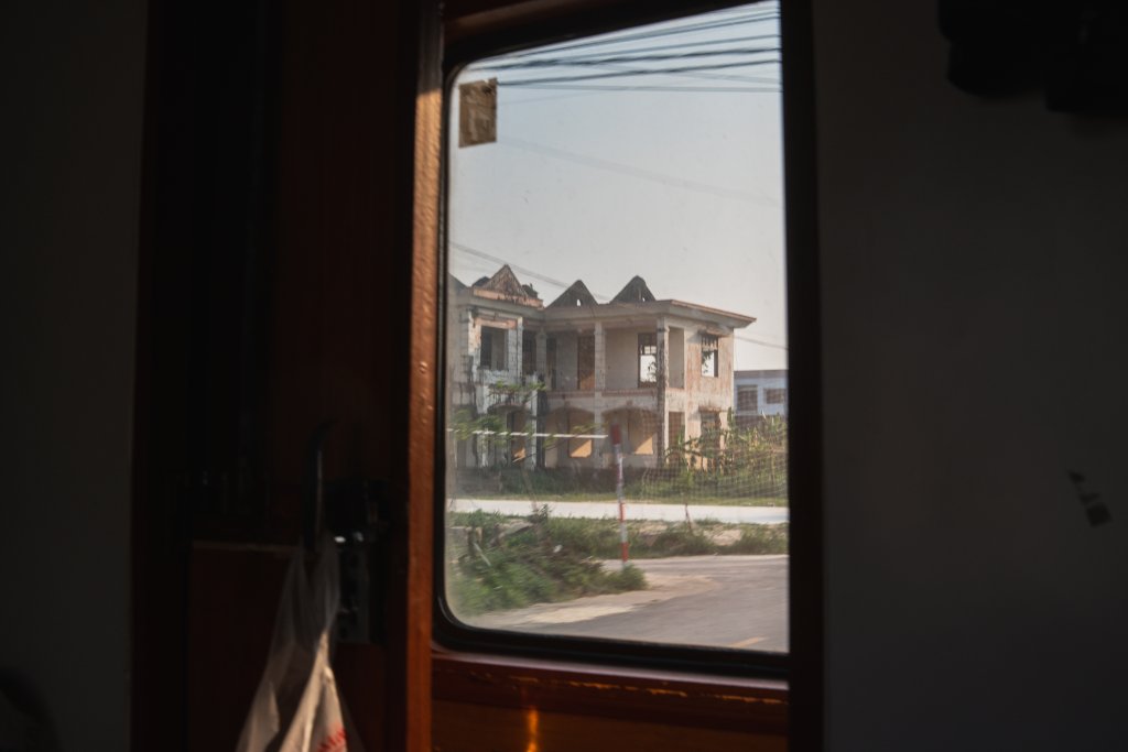 A view from a Vietnamese overnight train window across flat countryside.