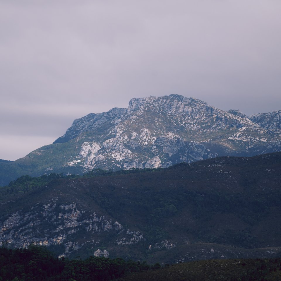 Sunlight breaking across rugged mountain peaks seen from Donaghys Hill.