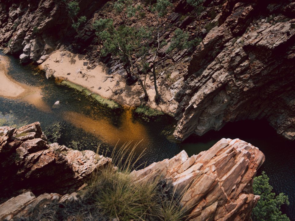 Aerial view of a Central Australian gorge with dark water and rocky terrain