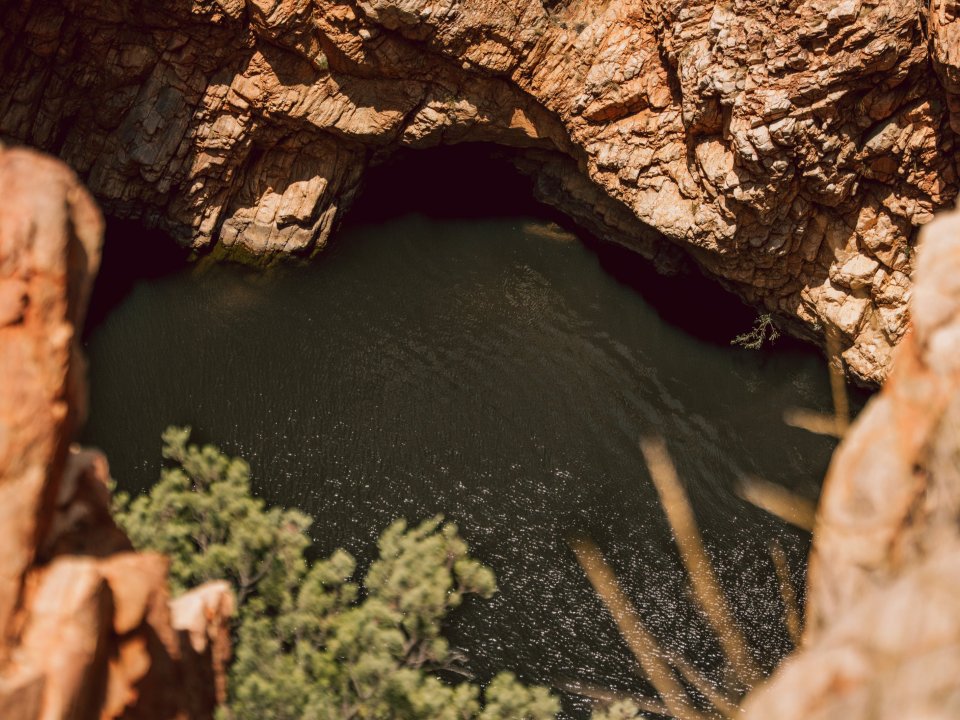 Rocky Central Australian gorge with a waterhole viewed from the clifftop above